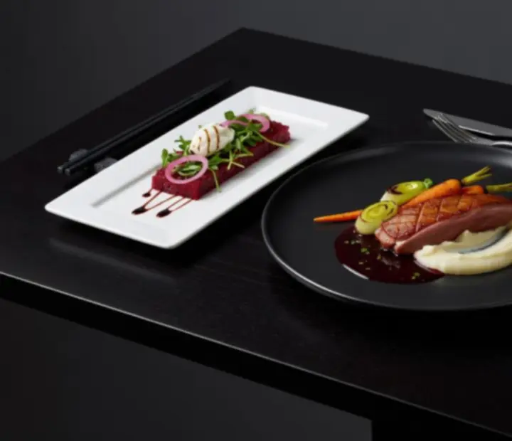 Szezonális fine dining fogás sötét tányéron, művészi tálalással